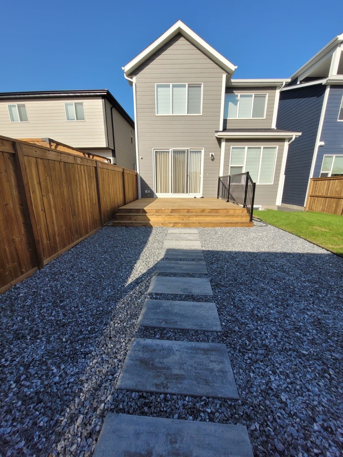 Custom Calgary backyard with artificial turf, paver patio, and stone edging
